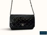 a black chanel bag with a chain strap on a white background