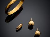 un gros plan d'une bague et d'une boucle d'oreille en or sur une surface noire