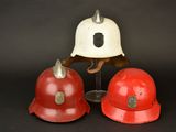 two firemen hats sitting next to each other on a black background