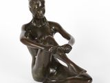une statue en bronze représentant une femme assise par terre