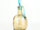 a glass bottle with a blue handle on a white surface