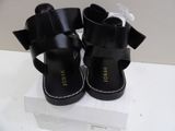 a pair of black sandals with a bow on them