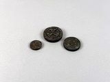 a close up of three coins sitting on top of a white surface