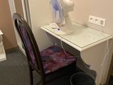 a fan that is sitting on a desk next to a chair