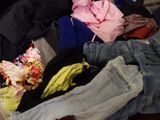 a pile of clothes sitting on the floor next to a bed