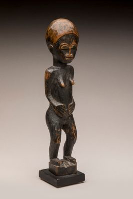 une statue en bois d'un homme avec un chapeau sur la tête
