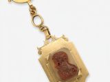 an image of a gold keychain with a picture of a woman on it