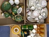 deux boîtes remplies de différentes sortes de tasses à thé et de soucoupes