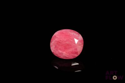 un gros plan d'une pierre rose sur une surface noire