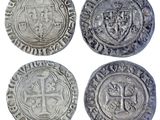 four silver coins with a cross and a shield on them
