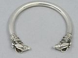 a close up of a silver bracelet with a bird on it