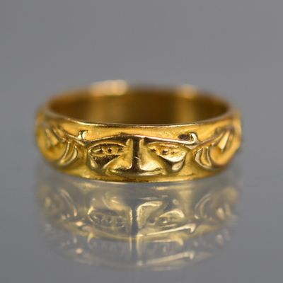 gros plan d'une bague en or sur une surface réfléchissante