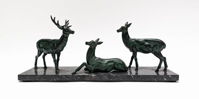 three bronze statues of deer on a marble base