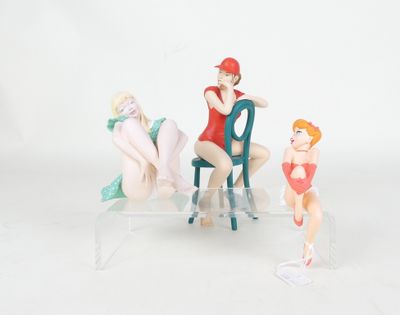 three figurines of a woman sitting on a chair