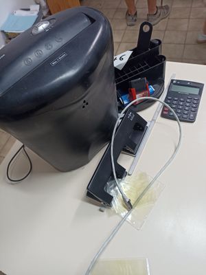 une cafetière noire posée sur une table, à côté d'une calculatrice