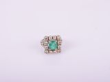 an emerald and diamond ring on a white background