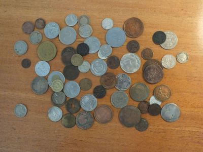 a pile of coins on a table next to a cell phone