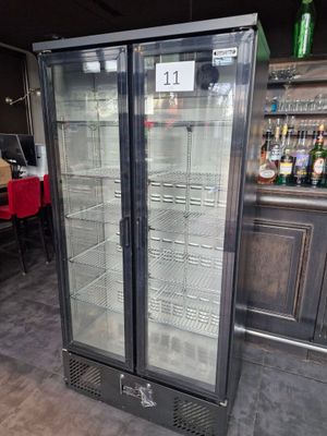 a glass door refrigerator in the middle of a room