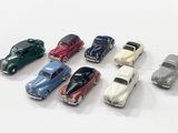 several toy cars are lined up in a row on a white surface