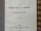 un livre ouvert posé sur une table à côté d'une pile de livres