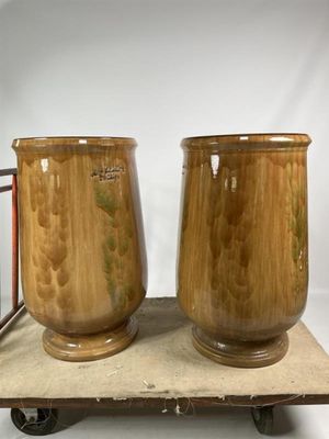 deux vases marron posés sur une charrette en bois