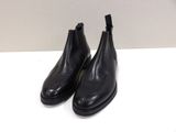a pair of black leather boots sitting on top of a white table