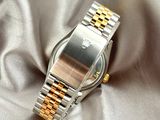 a silver and gold watch on a silver cloth