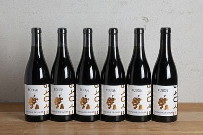 six bouteilles de vin sont alignées sur une table en bois