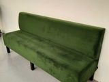 a green couch that is in a room with a lamp