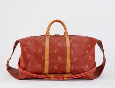 a red duffel bag sitting on a white surface