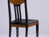 an image of a wooden chair with a black seat on a white background
