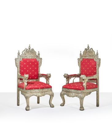 une paire de chaises argentées et rouges avec des coussins rembourrés rouges