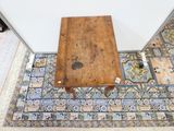 une petite table en bois posée sur un tapis au sol