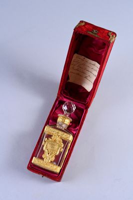 a bottle of perfume in a red box on a white surface