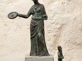 une statue représentant une femme tenant un frisbee, à côté d'une petite statue représentant un homme