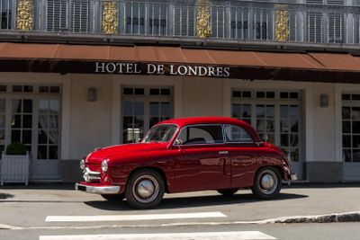 a red car parked in front of a hotel