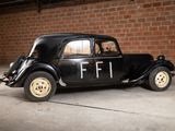 a black car parked in a garage with a brick wall behind it