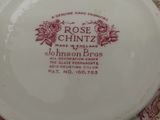 a white plate with a red rose design on it