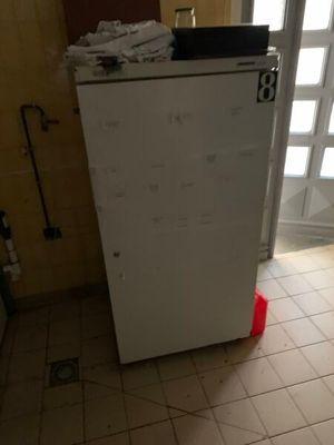 un réfrigérateur blanc posé dans le coin d'une pièce