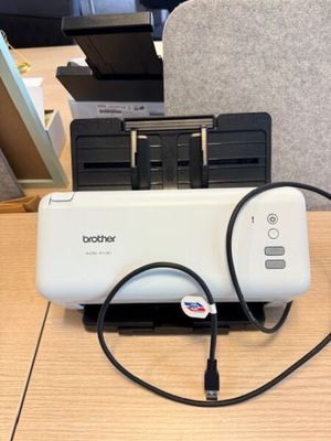 une imprimante branchée à un chargeur posé sur un bureau