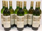 six bouteilles de vin sont alignées sur une table