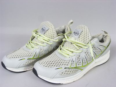 the white and yellow running shoes are on a white surface