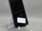 un téléphone portable posé sur un support et orné d'un autocollant