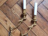 two candles are sitting on a wooden floor with rope wrapped around them
