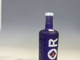 a bottle of vodka sitting on a counter next to a glass of wine