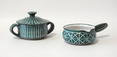 deux théières et une tasse posées sur un plan de travail blanc