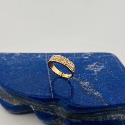 a close up of a gold ring on a blue stone