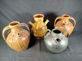 four different colored vases are lined up on a black background