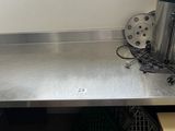 stainless steel counter top in a commercial kitchen with pots and pans on it