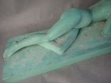 a statue of a woman laying down on a table